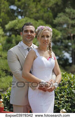 Bride and groom posing in a park View Large Photo Image Stock Image - Bride and groom posing in a park. Fotosearch