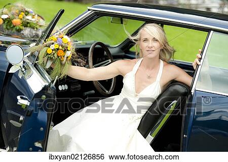 Stock Photograph - Bride in a classic car. Fotosearch
