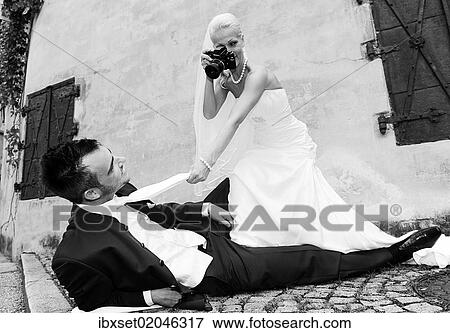 Stock Photo - "Bride photographing the groom with an old camera, photo shoot, wedding". Fotosearch