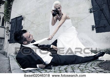 Stock Photo - "Bride photographing the groom with an old camera, photo shoot, wedding". Fotosearch