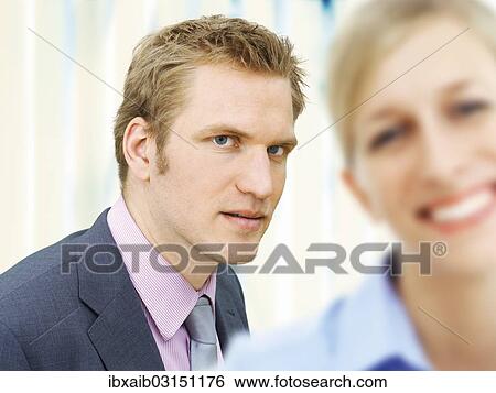 Businessman behind a smiling businesswoman View Large Photo Image Stock Photograph - Businessman behind a smiling businesswoman. Fotosearch