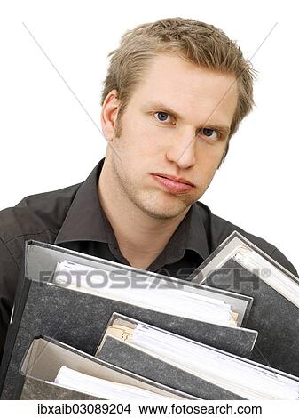 Picture - "Businessman carrying ring binders, looking exhausted, frustrated". Fotosearch