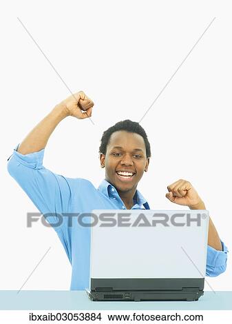 "Businessman, cheering while using a laptop" View Large Photo Image Picture - "Businessman, cheering while using a laptop". Fotosearch
