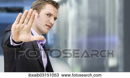 Businessman holding a hand up in a defensive manner in a subway station View Large Photo Image Stock Image - Businessman holding a hand up in a defensive manner in a subway station. Fotosearch
