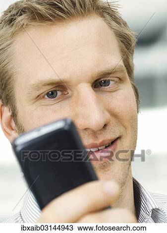 "Businessman holding a mobile phone, receiving a SMS" View Large Photo Image Stock Image - "Businessman holding a mobile phone, receiving a SMS". Fotosearch