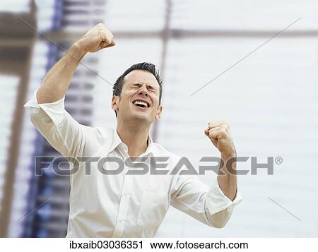 Businessman in an office cheering with clenched fists View Large Photo Image Stock Image - Businessman in an office cheering with clenched fists. Fotosearch