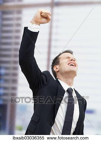 Businessman in an office cheering with a clenched fist View Large Photo Image Stock Photography - Businessman in an office cheering with a clenched fist. Fotosearch