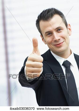 "Businessman in an office, making a thumbs up gesture" View Large Photo Image Stock Image - "Businessman in an office, making a thumbs up gesture". Fotosearch