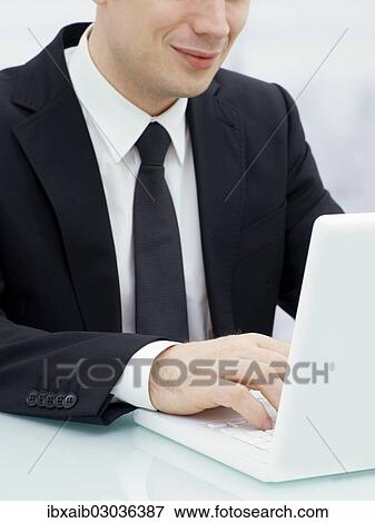 Businessman in an office with a laptop View Large Photo Image Stock Photo - Businessman in an office with a laptop. Fotosearch