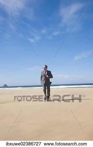 Businessman jogging along the beach View Large Photo Image Stock Photo - Businessman jogging along the beach. Fotosearch