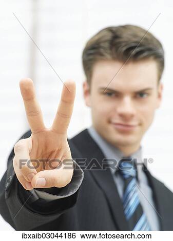 Stock Photograph - Businessman making a V-sign. Fotosearch