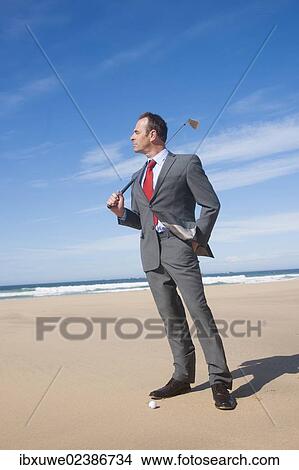 Businessman playing golf on the beach View Large Photo Image Picture - Businessman playing golf on the beach. Fotosearch