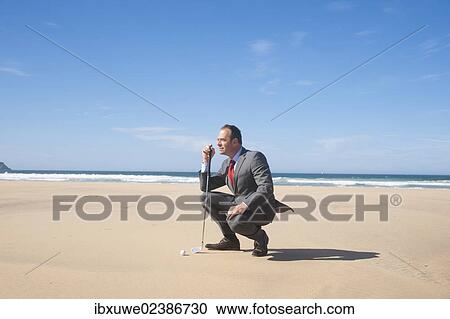 Businessman playing golf on the beach View Large Photo Image Stock Image - Businessman playing golf on the beach. Fotosearch