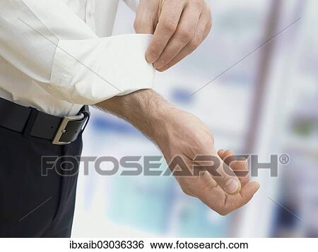 Businessman rolling up his sleeves View Large Photo Image Stock Photograph - Businessman rolling up his sleeves. Fotosearch