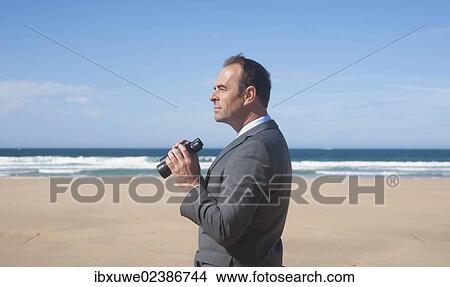 Businessman standing at the beach View Large Photo Image Picture - Businessman standing at the beach. Fotosearch