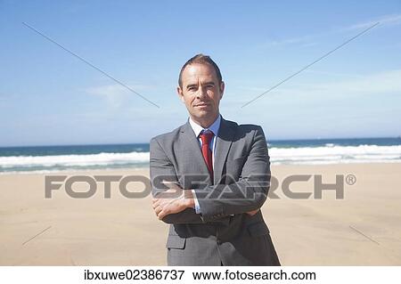 Businessman standing at the beach View Large Photo Image Stock Photo - Businessman standing at the beach. Fotosearch