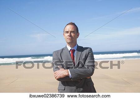 Stock Photo - Businessman standing at the beach. Fotosearch