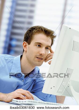 Stock Image - Businessman using a computer in an office. Fotosearch