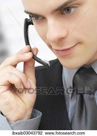 Businessman using a headset View Large Photo Image Stock Image - Businessman using a headset. Fotosearch