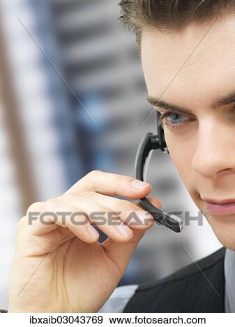 Businessman using a headset View Large Photo Image Stock Photo - Businessman using a headset. Fotosearch