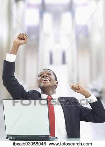Stock Photograph - "Businessman using a laptop in an office, jubilating". Fotosearch