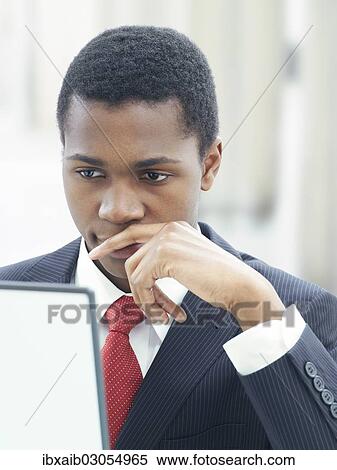 "Businessman using a laptop in an office, serious, thoughtful" View Large Photo Image Stock Photography - "Businessman using a laptop in an office, serious, thoughtful". Fotosearch