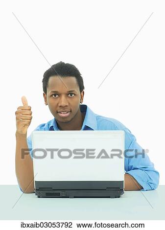 "Businessman, using a laptop, making a thumbs up gesture" View Large Photo Image Stock Image - "Businessman, using a laptop, making a thumbs up gesture". Fotosearch
