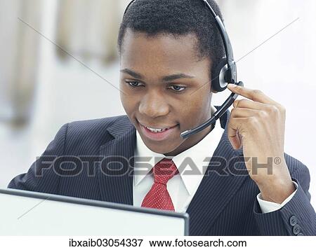 "Businessman, wearing a headset in an office" View Large Photo Image Stock Photo - "Businessman, wearing a headset in an office". Fotosearch