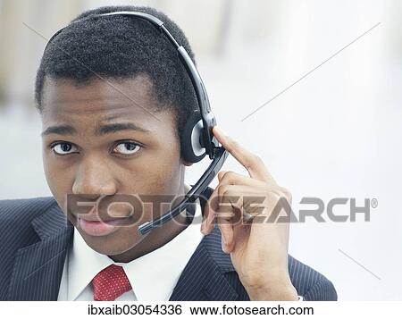 "Businessman, wearing a headset in an office" View Large Photo Image Stock Photograph - "Businessman, wearing a headset in an office". Fotosearch