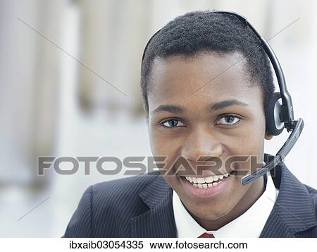 "Businessman, wearing a headset in an office" View Large Photo Image Stock Photography - "Businessman, wearing a headset in an office". Fotosearch