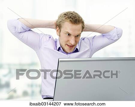 "Businessman working on a laptop, arms clasped behind his head, tense" View Large Photo Image Stock Photo - "Businessman working on a laptop, arms clasped behind his head, tense". Fotosearch