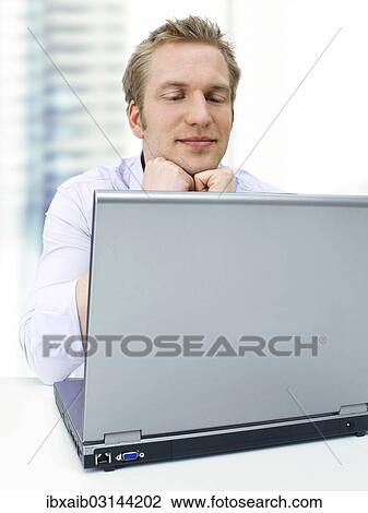"Businessman working on a laptop, calm" View Large Photo Image Stock Image - "Businessman working on a laptop, calm". Fotosearch