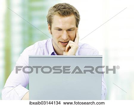 Businessman working on a laptop View Large Photo Image Picture - Businessman working on a laptop. Fotosearch