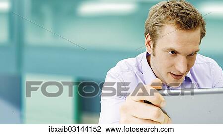 "Businessman working on a laptop, concentrating" View Large Photo Image Stock Image - "Businessman working on a laptop, concentrating". Fotosearch