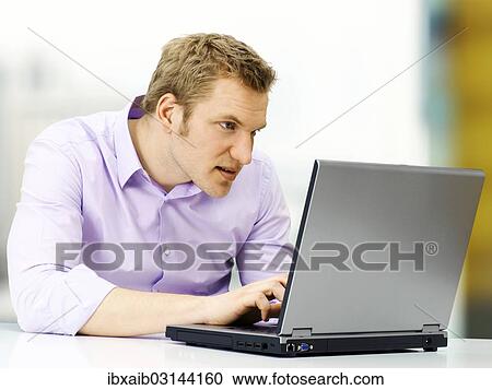 "Businessman working on a laptop, concentrating" View Large Photo Image Stock Image - "Businessman working on a laptop, concentrating". Fotosearch