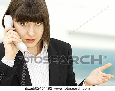 Businesswoman gesticulating while talking on the telephone with an expression of cluelessness View Large Photo Image Stock Image - Businesswoman gesticulating while talking on the telephone with an expression of cluelessness. Fotosearch
