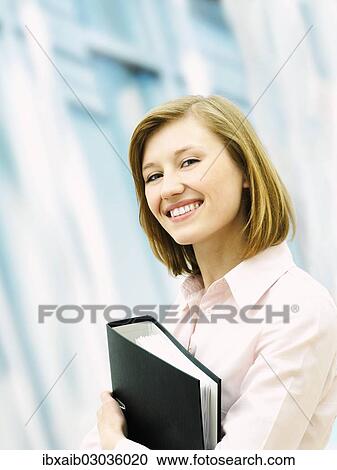 Businesswoman holding a ring binder View Large Photo Image Stock Image - Businesswoman holding a ring binder. Fotosearch