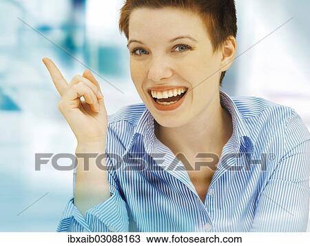 Stock Image - "Businesswoman in an office, smiling". Fotosearch