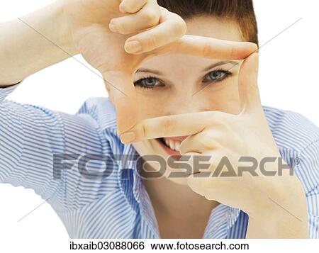 Stock Photograph - Businesswoman looking through her fingers as a frame. Fotosearch