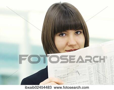 Stock Image - Businesswoman reading a newspaper. Fotosearch