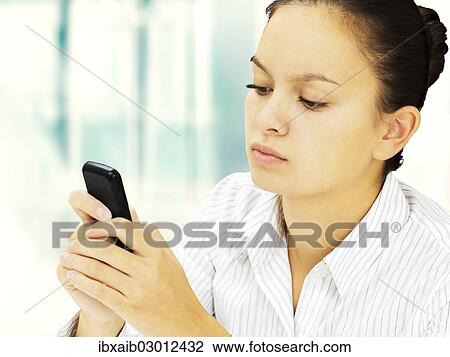 Businesswoman reading an SMS on a mobile phone View Large Photo Image Stock Image - Businesswoman reading an SMS on a mobile phone. Fotosearch
