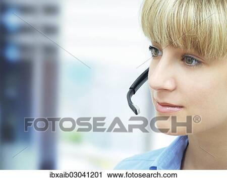 Businesswoman wearing a headset in an office View Large Photo Image Stock Image - Businesswoman wearing a headset in an office. Fotosearch