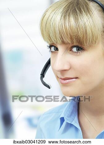 Stock Photo - Businesswoman wearing a headset in an office. Fotosearch
