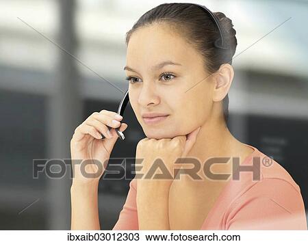 Stock Image - Businesswoman wearing a headset. Fotosearch