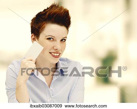 Stock Photo - Businesswoman with a punk hairstyle holding a blank business card. Fotosearch