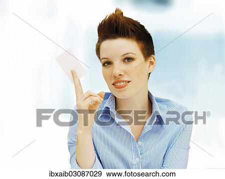 Stock Photo - Businesswoman with a punk hairstyle holding a blank business card. Fotosearch