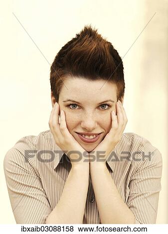 "Businesswoman with a punk hairstyle, supporting her head in her hands, smiling" View Large Photo Image Stock Photo - "Businesswoman with a punk hairstyle, supporting her head in her hands, smiling". Fotosearch