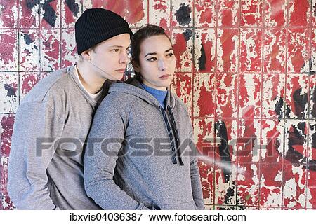 "Casual and relaxed young man and woman waiting in front of grafitti wall in urban area, Sweden, Europe" View Large Photo Image Stock Photo - "Casual and relaxed young man and woman waiting in front of grafitti wall in urban area, Sweden, Europe". Fotosearch