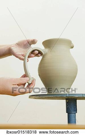Stock Photo - "Ceramic artist working in her workshop, pulling a handle for a pitcher, Geisenhausen, Bavaria, Germany, Europe". Fotosearch