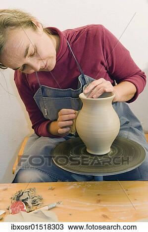 "Ceramic artist working in her workshop with a potter's wheel, polishing the surface of a pitcher, Geisenhausen, Bavaria, Germany, Europe" View Large Photo Image Stock Image - "Ceramic artist working in her workshop with a potter's wheel, polishing the surface of a pitcher, Geisenhausen, Bavaria, Germany, Europe". Fotosearch